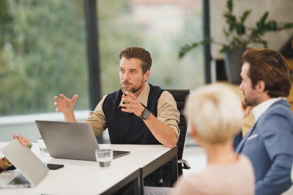Colegas em uma reunião rápida ao redor de uma mesa com notebook