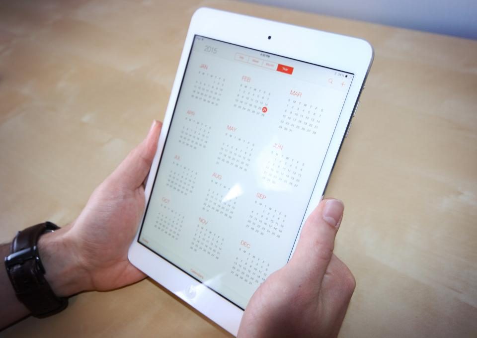 Mãos segurando um tablet com o calendário da semana aberto